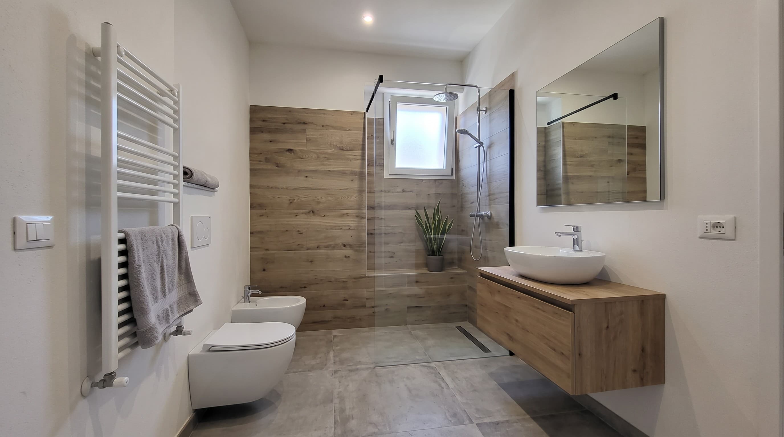 Bagno ristrutturato con doccia a filo pavimento e gres effetto legno