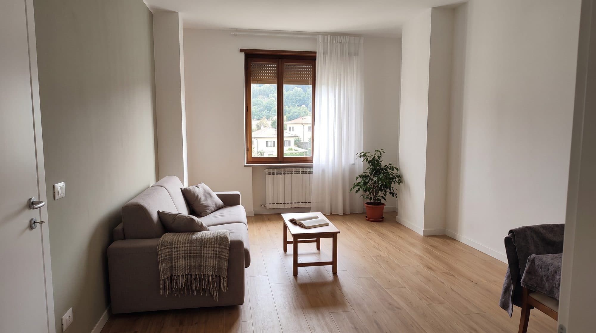Soggiorno consegnato: divano chiaro, tavolino in legno e parquet