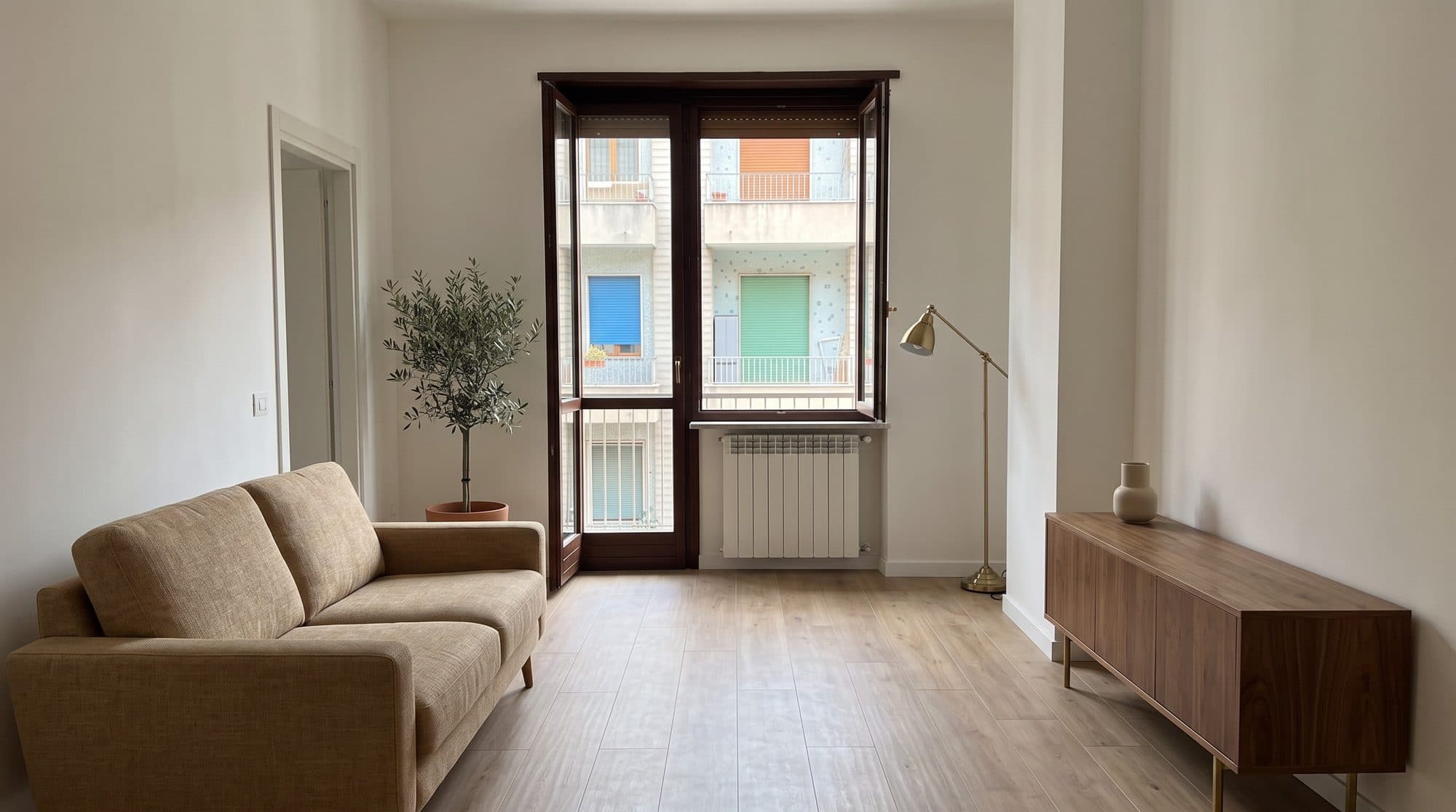 Soggiorno ristrutturato in un appartamento milanese, parquet e luce naturale